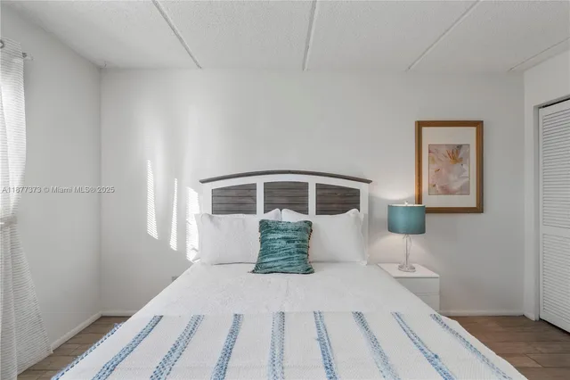 a bedroom with a bed and a painting on the wall