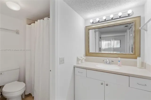 a bathroom with a sink vanity mirror and toilet