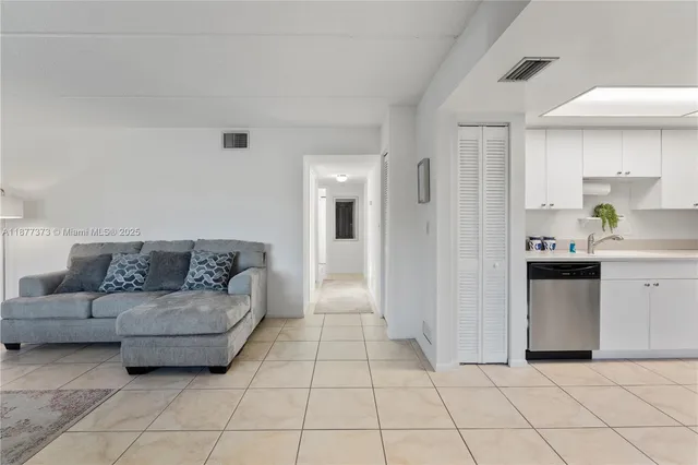 a living room with furniture and kitchen view