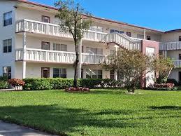 29 Preston A Boca Raton, FL 33434 - Photo 2 of 21 a front view of a building with a garden