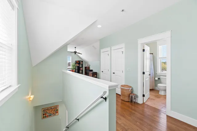 a view of a hallway with wooden floor and staircase