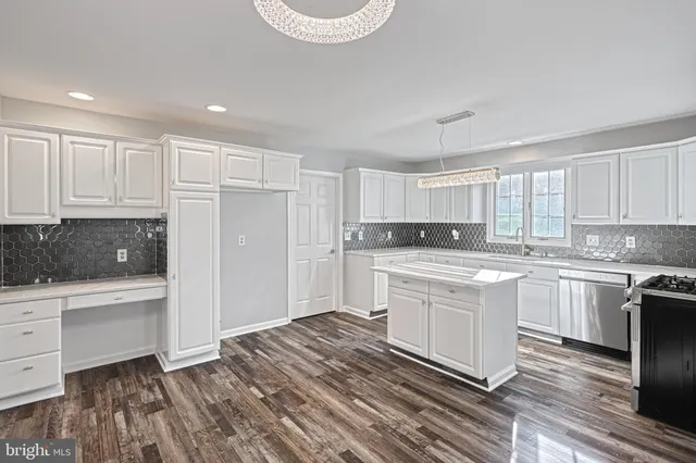 a living room with furniture a flat screen tv and a refrigerator