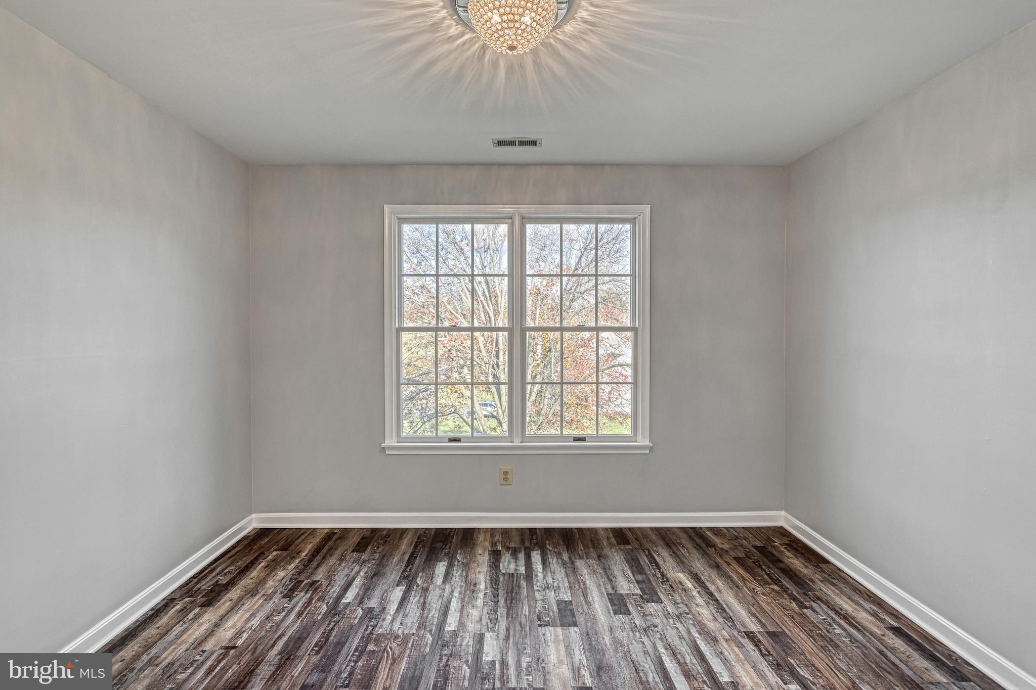 14 Kratz Road Shrewsbury, PA 17361 - Photo 61 of 137 an empty room with wooden floor a chandelier fan and windows