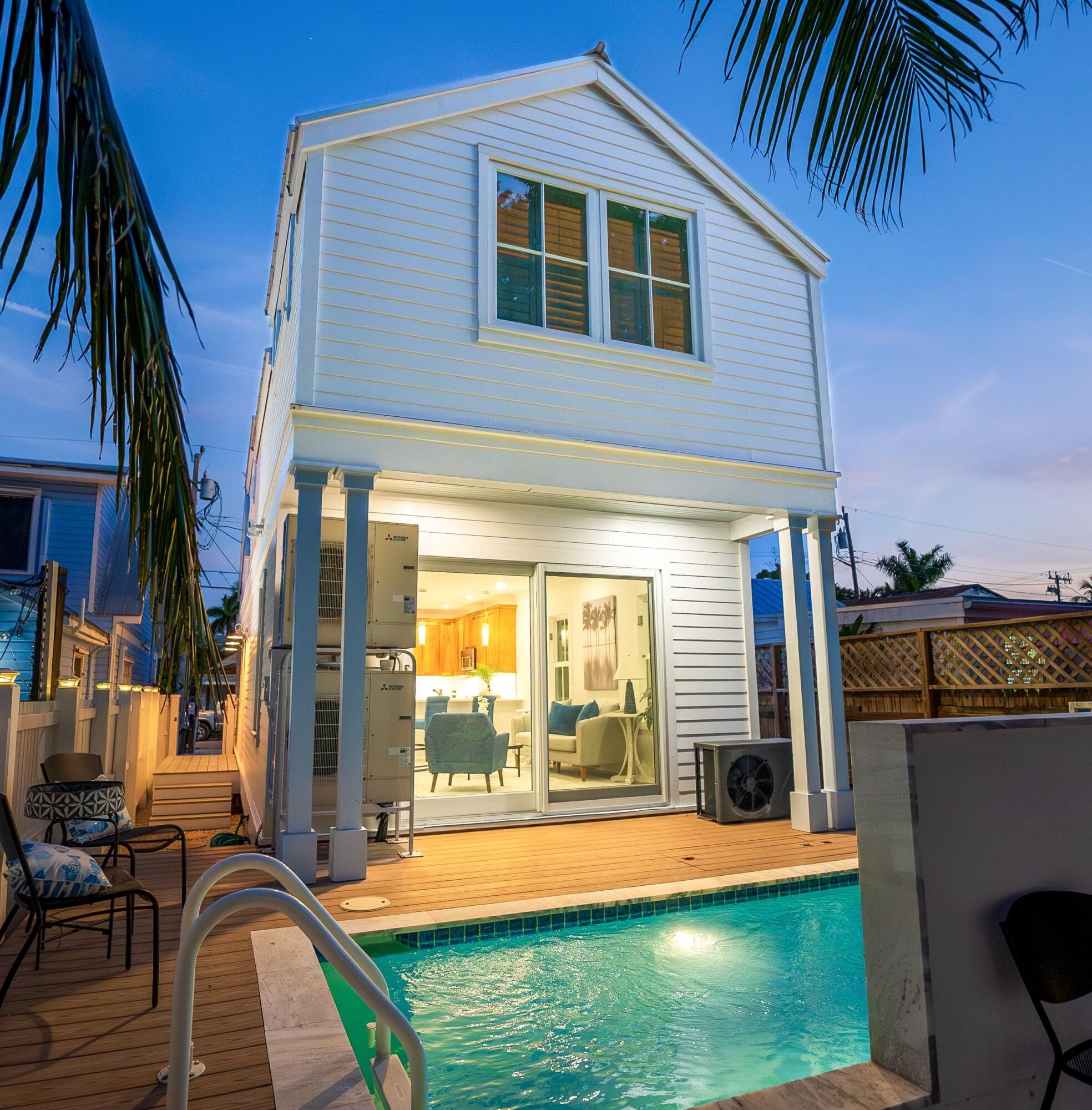 317 Virginia Street Key West, FL 33040 - Photo 27 of 47 a front view of a house with a yard table and chairs