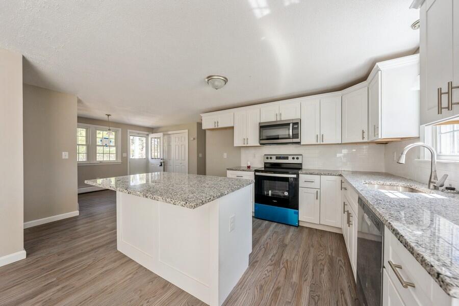 51 Carrie Lee's Way Centerville, MA 02632 - Photo 5 of 15 a kitchen with stainless steel appliances granite countertop a stove top oven a sink dishwasher a refrigerator and white cabinets with wooden floor