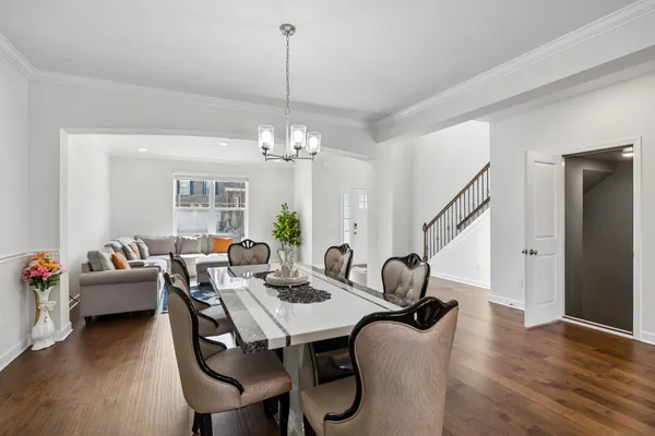 a dining room with furniture a chandelier and wooden floor