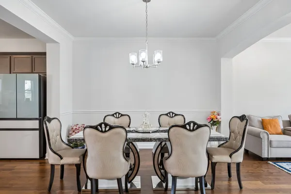 a view of a dining room with furniture wooden floor and chandelier