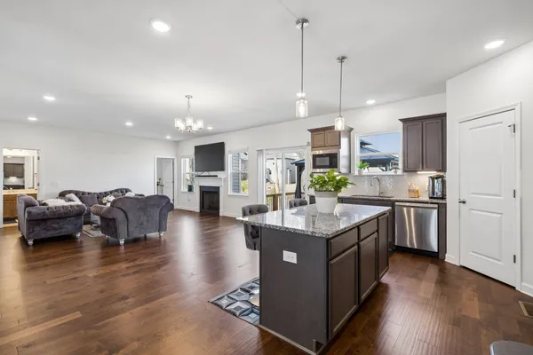 a kitchen with stainless steel appliances granite countertop a refrigerator a stove and a wooden floors