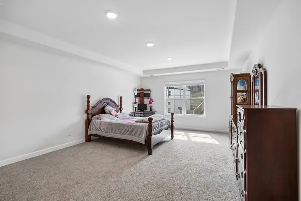 a bedroom with a bed and a flat tv screen on dresser