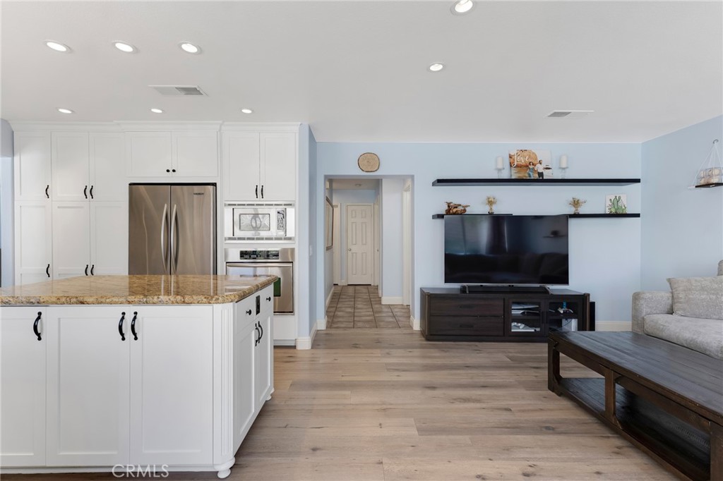 3843 San Gabriel Street Simi Valley, CA 93063 - Photo 22 of 52 a living room with stainless steel appliances kitchen island a flat screen tv and a refrigerator