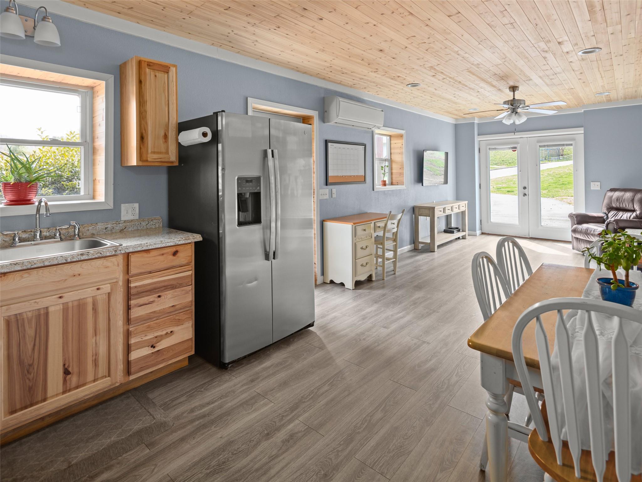 150 Barefoot Ridge Clyde, NC 28721 - Photo 15 of 27 a kitchen with stainless steel appliances granite countertop a refrigerator a stove a sink dishwasher a dining table and chairs with wooden floor