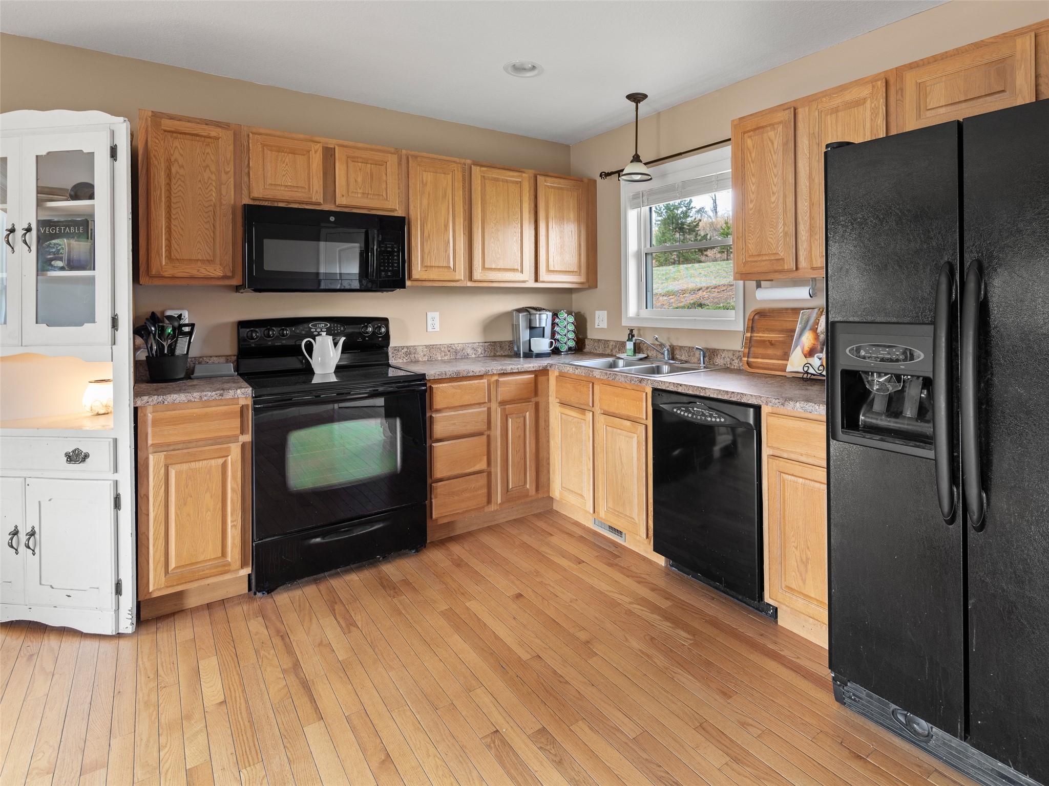 150 Barefoot Ridge Clyde, NC 28721 - Photo 6 of 27 a kitchen with stainless steel appliances granite countertop a refrigerator a stove top oven a sink and dishwasher with wooden floor