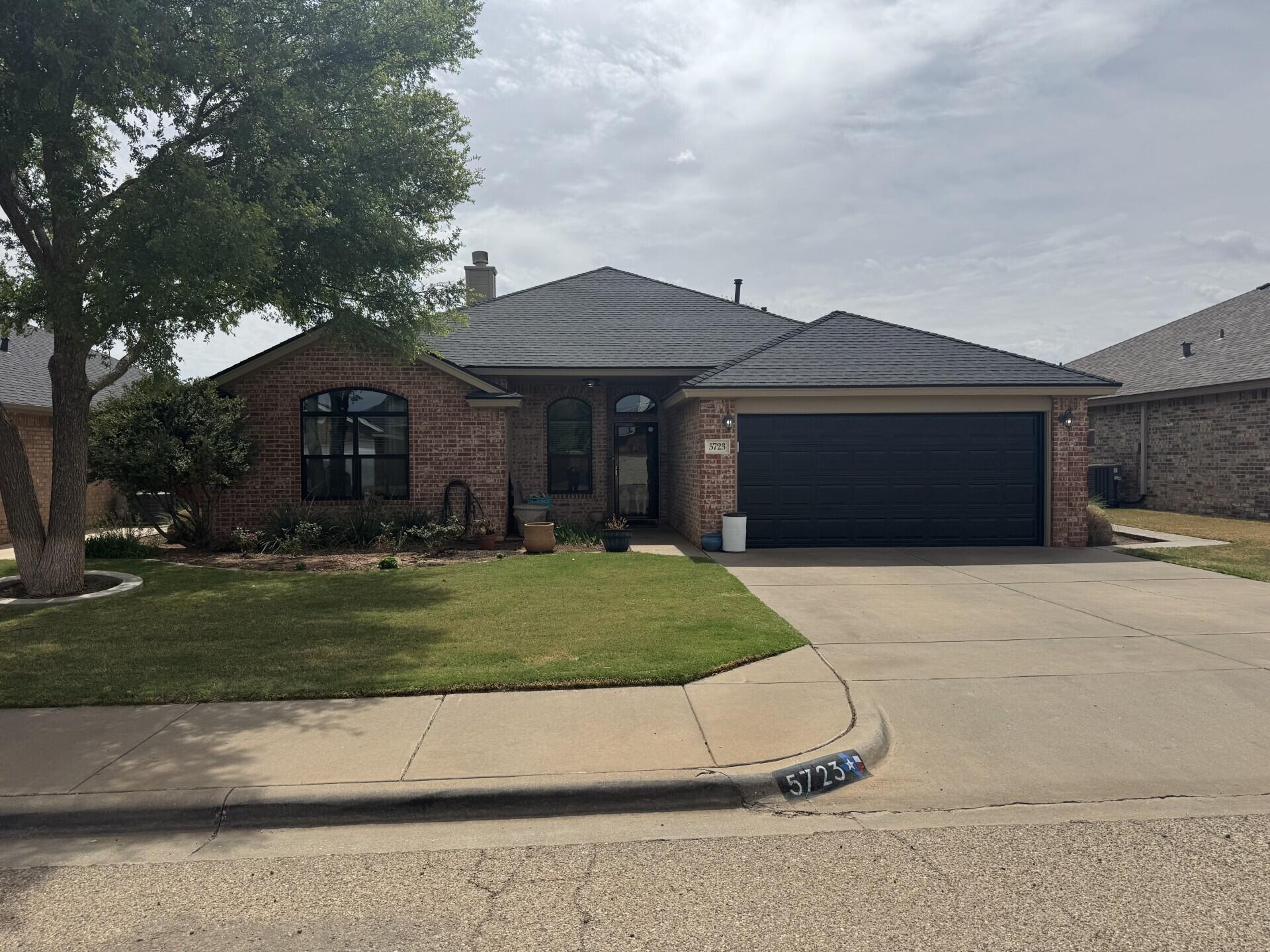 5723 107th Street Lubbock, TX 79424 - Photo 1 of 1 a front view of a house with a garden and trees