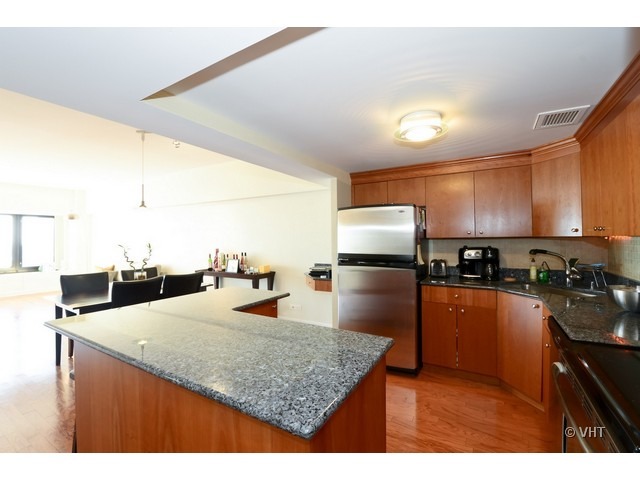 175 East Delaware Place, Unit 4522 Chicago, IL 60611 - Photo 5 of 15 a kitchen with stainless steel appliances kitchen island granite countertop a sink refrigerator and cabinets