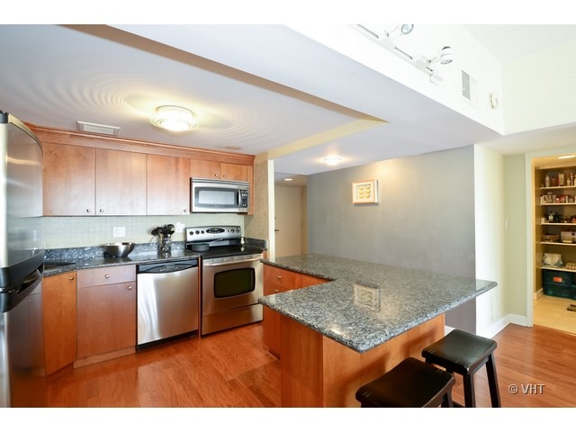 175 East Delaware Place, Unit 4522 Chicago, IL 60611 - Photo 6 of 15 a kitchen with stainless steel appliances granite countertop a sink counter space and cabinets