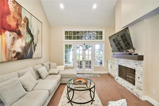 a living room with furniture a fireplace and a floor to ceiling window