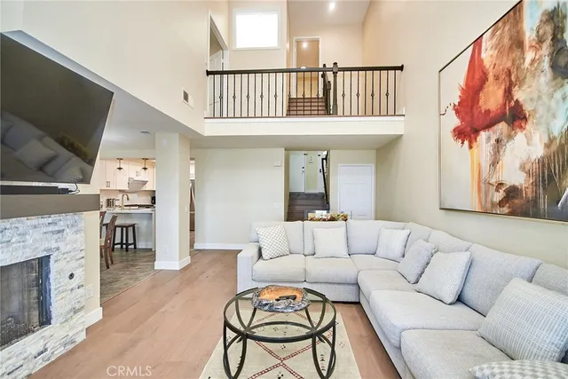 a living room with furniture a flat screen tv and a fireplace