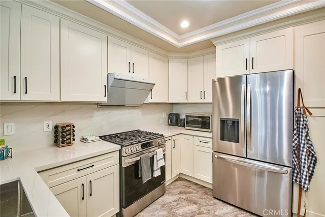 a kitchen with cabinets stainless steel appliances and a counter space