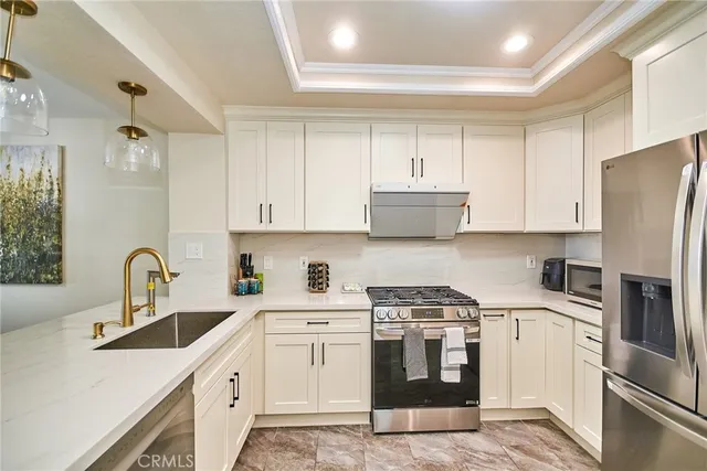 a kitchen with stainless steel appliances a refrigerator sink and white cabinets