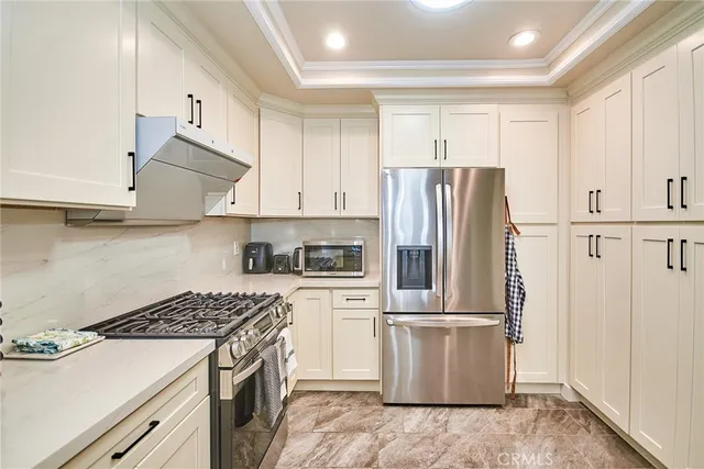 a kitchen with a stove a refrigerator and cabinets