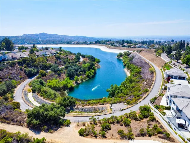 an aerial view of a house with a garden and lake view