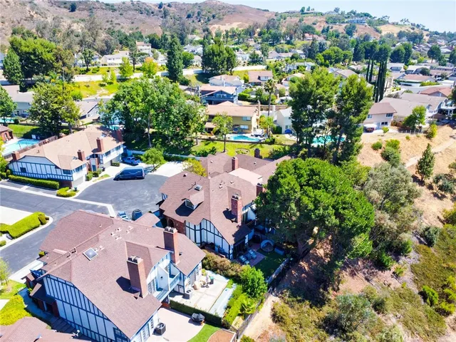 an aerial view of residential houses with outdoor space and parking