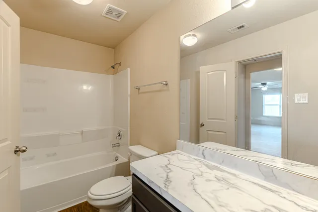 an empty room with a bathroom and a mirror