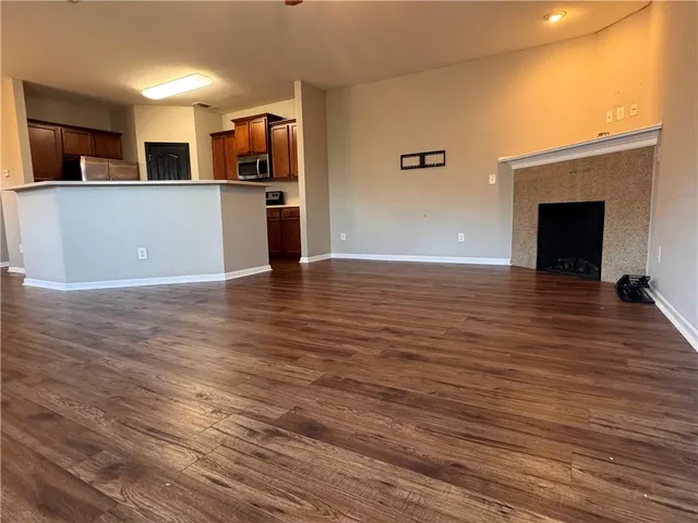 a view of a kitchen with wooden floor and a fireplace