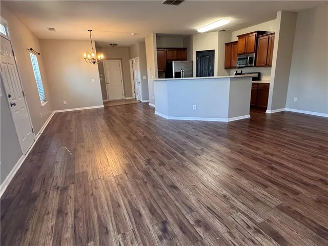 a view of a kitchen with wooden floor and a refrigerator