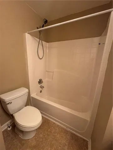 a bathroom with a bathtub shower sink vanity and toilet