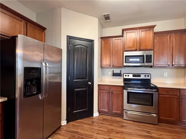 a kitchen with stainless steel appliances granite countertop a refrigerator and a stove top oven
