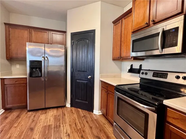 a kitchen with granite countertop wooden cabinets stainless steel appliances and a counter space
