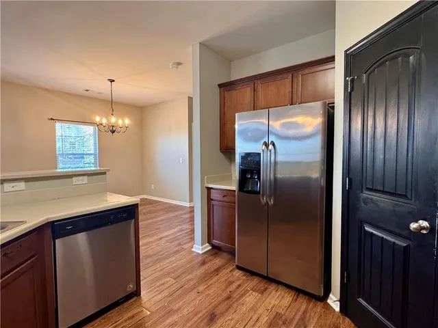 a kitchen with kitchen island a counter top space wooden floor and stainless steel appliances