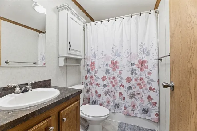 a bathroom with a granite countertop sink a toilet and a mirror