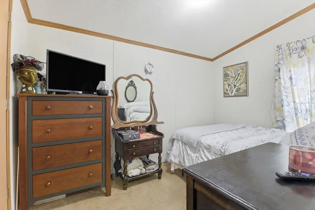 a bedroom with a bed and flat screen tv