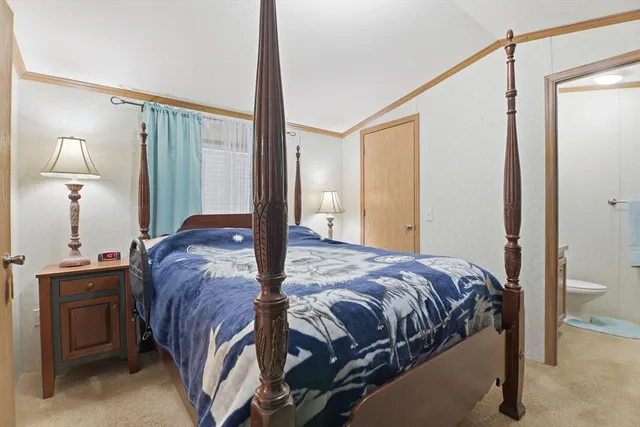 a bedroom with a bed and a lamp on dresser