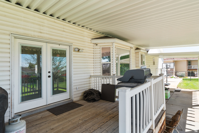 5727 South 3550th Street West Roy, UT 84067 - Photo 36 of 49 Covered patio with wood-finish decking and white vinyl siding
