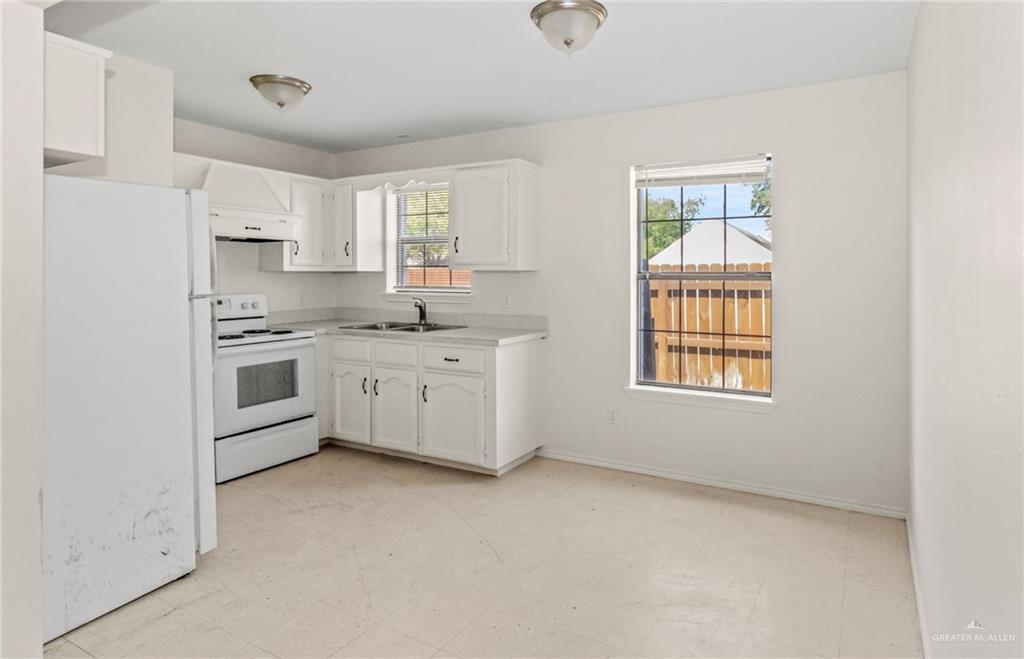 4601 South 24th Street, Unit 7 McAllen, TX 78503 - Photo 3 of 7 Kitchen featuring white appliances, white cabinetry, and healthy amount of natural light