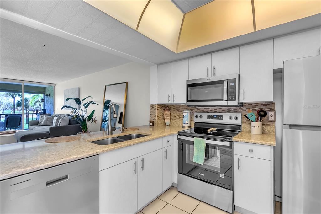12200 Vonn Road, Unit 2206 Largo, FL 33774 - Photo 10 of 60 a kitchen with white cabinets and stainless steel appliances