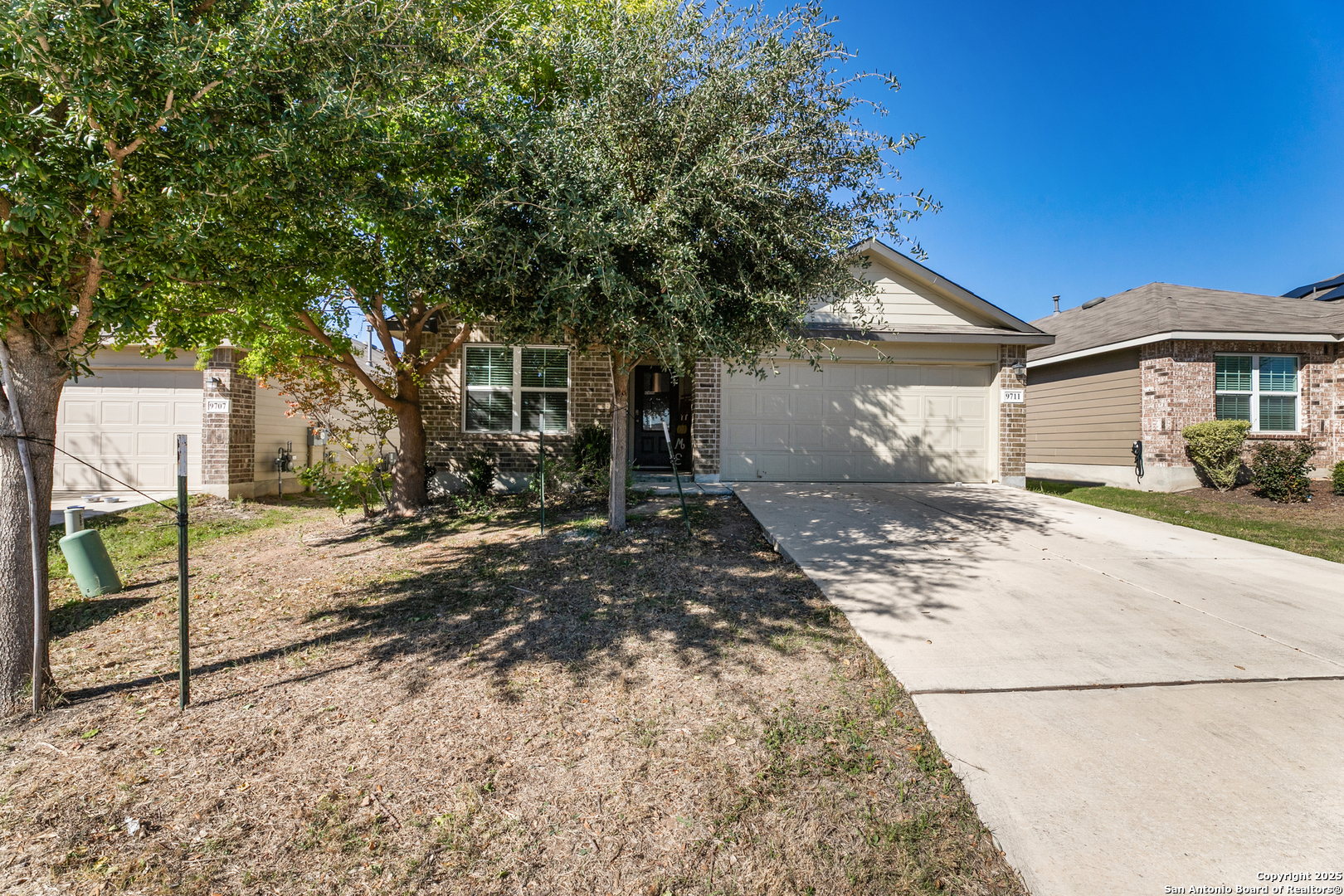 9711 Bratten Rise San Antonio, TX 78254 - Photo 1 of 19 a view of a white house with a large tree in front of it