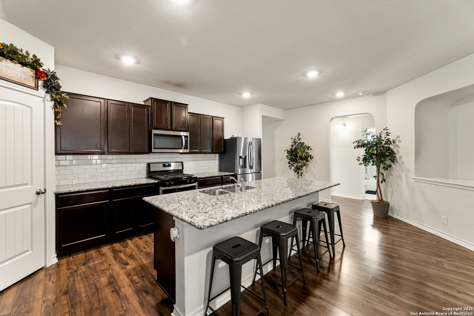 9711 Bratten Rise San Antonio, TX 78254 - Photo 5 of 19 a kitchen with granite countertop kitchen island stainless steel appliances a stove refrigerator sink and cabinets
