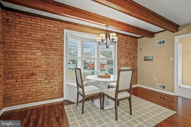 a view of a room with a wooden table and chairs