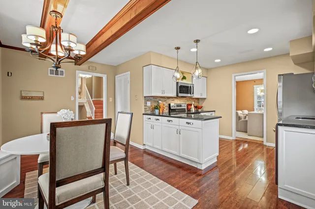 a kitchen with a dining table chairs refrigerator and cabinets