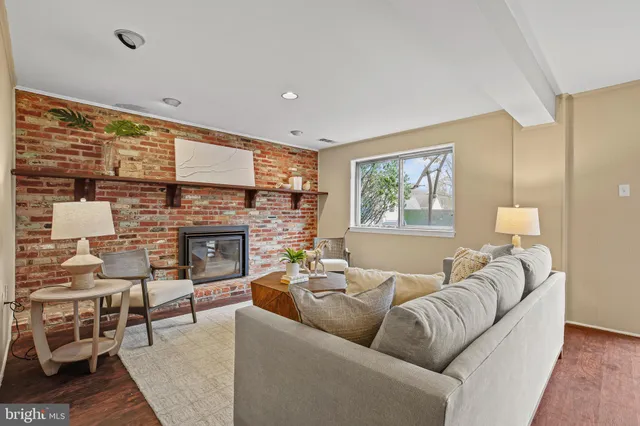 a living room with furniture a large window and a fireplace