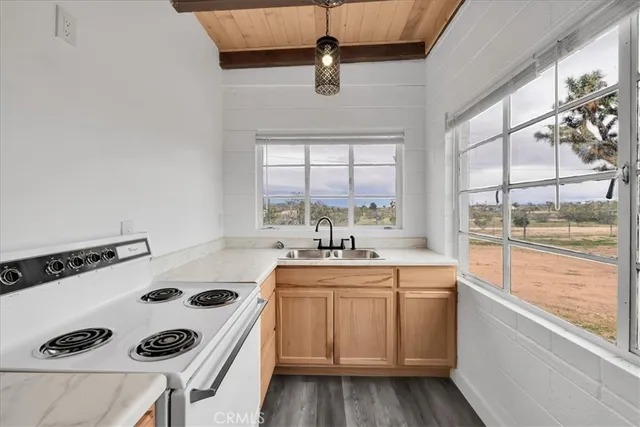 a kitchen with a sink a stove and white cabinets