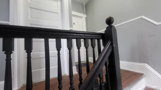 a view of a hallway with wooden floor and staircase