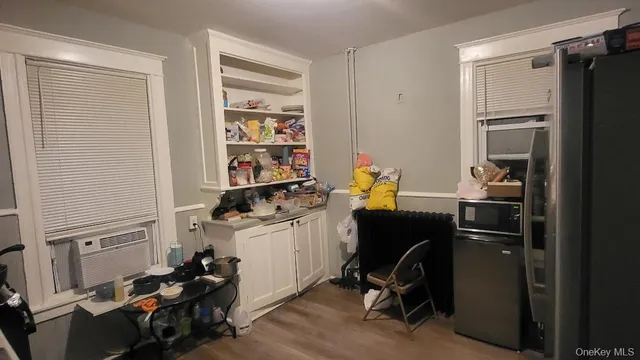 a room with a refrigerator and a wooden floor