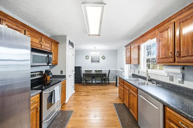 a kitchen with stainless steel appliances granite countertop a refrigerator and a stove top oven