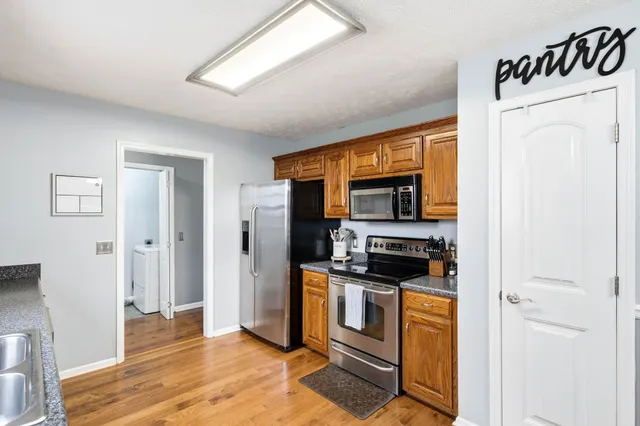 a kitchen with stainless steel appliances granite countertop a sink stove and refrigerator