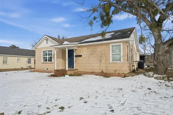 a view of a house with a yard covered in snow
